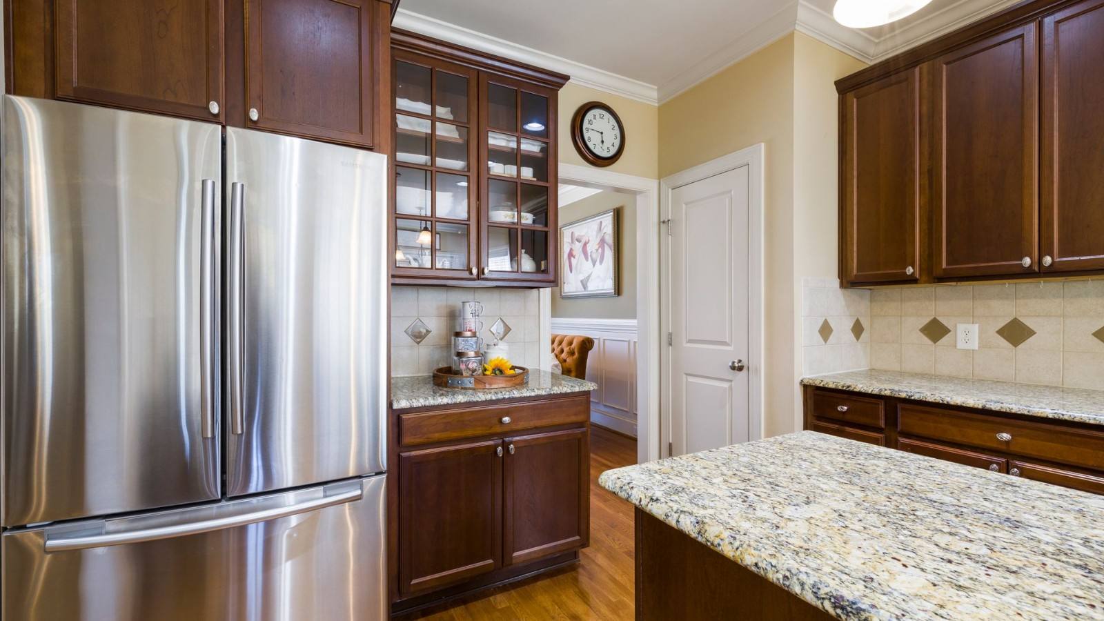 Stainless steel French-door refrigerator in a kitchen with wood cabinets